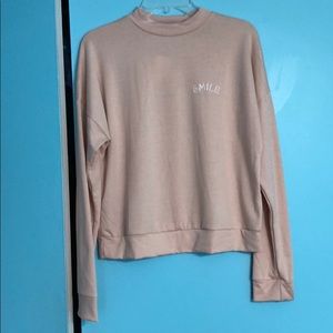 A light sweater with a smile logo